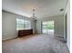 Bright living room with a classic chandelier and sliding door access to the pool at 27610 Debbie Rd, Okahumpka, FL 34762