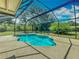 Sparkling pool with a screened enclosure, surrounded by lush landscaping at 27610 Debbie Rd, Okahumpka, FL 34762