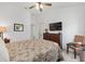 Comfortable bedroom features wood-look floors, ceiling fan, tv, and tasteful furnishings at 2988 Sentell St, The Villages, FL 32163