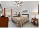 Cozy bedroom with a ceiling fan, a window and warm tones perfect for relaxing and unwinding at 2988 Sentell St, The Villages, FL 32163
