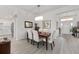 Elegant dining room with hardwood floors, stylish lighting, and a view into the kitchen and front entrance at 2988 Sentell St, The Villages, FL 32163