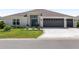 Charming home featuring a well-manicured lawn, a two-car garage, and decorative front door with a wreath at 2988 Sentell St, The Villages, FL 32163