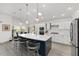 The kitchen features a large island with seating, quartz countertops, pendant lighting, and stainless steel appliances at 2988 Sentell St, The Villages, FL 32163