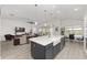 The kitchen is equipped with a large island with a farmhouse sink, pendant lighting, and stainless steel appliances at 2988 Sentell St, The Villages, FL 32163