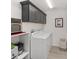 Modern laundry room with gray cabinets, countertop and a new washer and dryer at 2988 Sentell St, The Villages, FL 32163