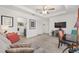 Open-concept living room with a modern couch, a ceiling fan, and easy access to the powder room at 2988 Sentell St, The Villages, FL 32163