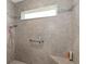 Shower features neutral tile, a window, and built-in bench offering a spa-like experience at 2988 Sentell St, The Villages, FL 32163