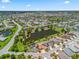 Aerial view shows a well-maintained community with homes surrounding scenic ponds and winding roads at 2998 Kramer Ct, The Villages, FL 32163