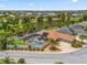 Aerial photo of a well-maintained home with a screened pool, landscaped yard, and a tranquil lake backdrop at 2998 Kramer Ct, The Villages, FL 32163
