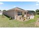 Well-maintained backyard with lush landscaping, a cozy patio, and a screened pool area, perfect for outdoor living at 2998 Kramer Ct, The Villages, FL 32163