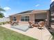 Backyard patio featuring comfortable wicker furniture and a screened lanai, ideal for outdoor living at 2998 Kramer Ct, The Villages, FL 32163