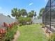 Lush backyard featuring a green lawn, privacy fence, and a screened-in patio for outdoor enjoyment at 2998 Kramer Ct, The Villages, FL 32163