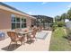 Backyard patio area with comfortable seating, perfect for enjoying the Florida weather and a view of the screened lanai at 2998 Kramer Ct, The Villages, FL 32163