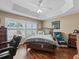 Cozy bedroom with ceiling fan, hardwood floors, and an Eagles-themed chair and decor at 2998 Kramer Ct, The Villages, FL 32163