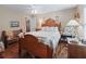Spacious bedroom featuring hardwood floors, a wooden bed frame, and a bright window at 2998 Kramer Ct, The Villages, FL 32163