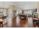 Inviting living room with wood floors, vaulted ceilings, ample seating, and natural light from sliding glass doors at 2998 Kramer Ct, The Villages, FL 32163
