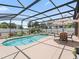 Inviting screened pool and patio area with outdoor seating, perfect for entertaining or relaxing in the sun at 2998 Kramer Ct, The Villages, FL 32163