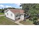 Quaint home featuring a manicured lawn, sidewalk, and mature trees at 30 E Key Ave, Eustis, FL 32726