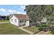 Exterior angled front view of the property featuring a lawn and a mature tree at 30 E Key Ave, Eustis, FL 32726