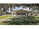 Exterior view of the property featuring mature trees and a well-maintained lawn at 30 E Key Ave, Eustis, FL 32726
