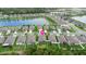 An aerial view shows residential neighborhood with mature trees, playgrounds in backyards, and a community pond at 3060 Neverland Dr, New Smyrna Beach, FL 32168