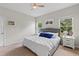 Bright bedroom with a queen bed, side tables and windows offering views of the backyard at 3060 Neverland Dr, New Smyrna Beach, FL 32168