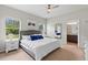 Comfortable bedroom featuring a queen bed, plush linens, bright windows, and an ensuite bathroom at 3060 Neverland Dr, New Smyrna Beach, FL 32168