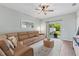 Comfortable living room with a plush sectional sofa, ceiling fan, and sliding glass doors to patio at 3060 Neverland Dr, New Smyrna Beach, FL 32168