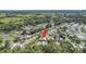 Aerial view showing the property's location in a quiet community surrounded by trees and with a nearby pond at 32335 Oak Park Dr, Leesburg, FL 34748