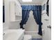 Well-lit bathroom featuring blue tile floor and a shower with a charming blue ruffled shower curtain at 32335 Oak Park Dr, Leesburg, FL 34748