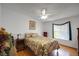 Inviting bedroom featuring a ceiling fan, floral bedding, and natural light from a large window at 32335 Oak Park Dr, Leesburg, FL 34748