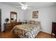 Comfortable bedroom with a ceiling fan, floral bedding, dresser and ample natural light at 32335 Oak Park Dr, Leesburg, FL 34748