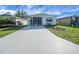 Welcoming exterior featuring a long driveway, screened-in porch, and a neatly kept lawn, creating a cozy atmosphere at 32335 Oak Park Dr, Leesburg, FL 34748