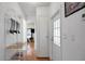 Hallway with hardwood floors that leads to the living room and has a convenient coat rack at 32335 Oak Park Dr, Leesburg, FL 34748