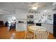 Bright kitchen with stainless steel appliances, white cabinetry, and a casual dining area with wood flooring at 32335 Oak Park Dr, Leesburg, FL 34748
