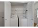 Convenient laundry closet with washer, dryer, and shelving for organized storage solutions at 32335 Oak Park Dr, Leesburg, FL 34748