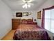 Well-lit main bedroom featuring a queen-size bed with decorative pillows and comfortable furnishings at 32335 Oak Park Dr, Leesburg, FL 34748