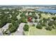 An aerial view of a neighborhood with lush trees and a lake in the distance at 3559 Chapel Hill Blvd, Clermont, FL 34711