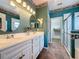 Bathroom with double sink vanity, oval mirrors, tile flooring and glass-enclosed shower at 3559 Chapel Hill Blvd, Clermont, FL 34711