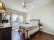 Bedroom with wood floors, ceiling fan, window with sheer curtains, and queen bed at 3559 Chapel Hill Blvd, Clermont, FL 34711