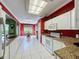 Bright kitchen featuring white cabinets, granite countertops, white appliances and red accent wall at 3559 Chapel Hill Blvd, Clermont, FL 34711