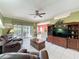 Bright living room with tile floors, ceiling fan, and sliding glass doors to the lanai at 3559 Chapel Hill Blvd, Clermont, FL 34711