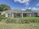 Enclosed patio with a hot tub and screen enclosure, surrounded by lush greenery for privacy at 3559 Chapel Hill Blvd, Clermont, FL 34711