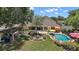 Backyard featuring an in-ground fenced pool, a cozy firepit, covered patio and manicured garden at 397 Anderson Dr, Tavares, FL 32778