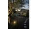 Enchanting backyard featuring a winding stone path, lush greenery, and subtle lighting, creating a serene ambiance at 397 Anderson Dr, Tavares, FL 32778
