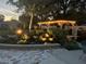 Lush backyard featuring ambient lighting, a charming gazebo, and a serene waterfall feature for relaxation and ambiance at 397 Anderson Dr, Tavares, FL 32778