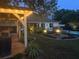 Backyard with a covered patio, pool, and fire pit, illuminated for evening enjoyment and entertainment at 397 Anderson Dr, Tavares, FL 32778