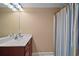 Well-lit bathroom with a single vanity, mirror, and a shower with a colorful curtain providing privacy at 397 Anderson Dr, Tavares, FL 32778