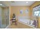 This beige bathroom features a walk-in shower, soaking tub, and window overlooking the backyard at 397 Anderson Dr, Tavares, FL 32778