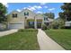 Traditional home with a two car garage, green shutters, and manicured landscaping at 397 Anderson Dr, Tavares, FL 32778